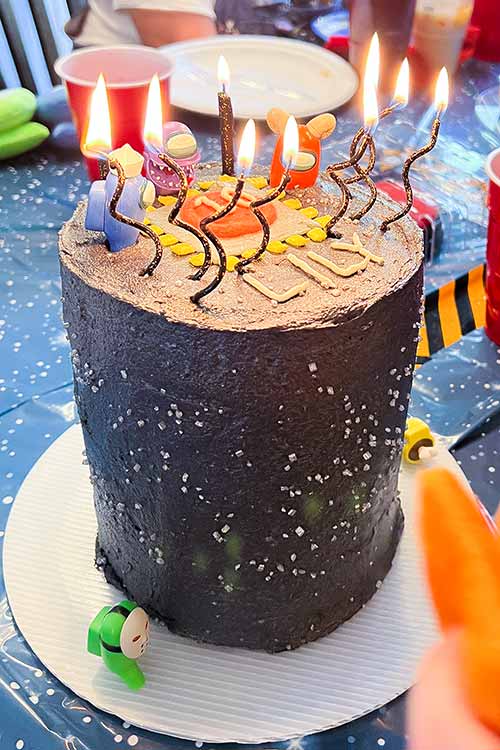 an Among Us cake with lit twisted candles