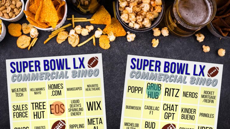Two Super Bowl commercial bingo cards on a table with snacks, popcorn, chips, nuts, and glasses of beer around them.