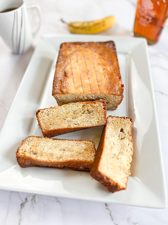 loaf of three-ingredient banana bread with 3 slices on a white platter