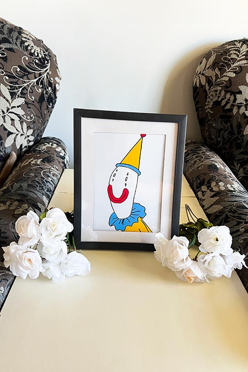 framed photo of Kaufmo surrounded by small white rose bouquets