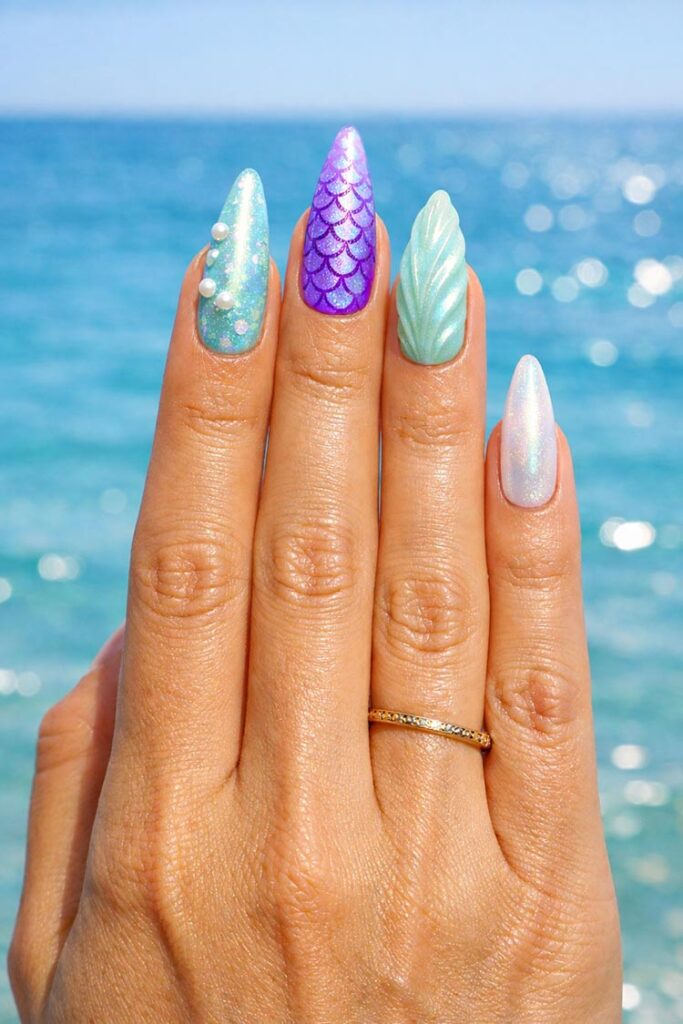 Long mermaid nails with iridescent scales, pearls, and ocean tones