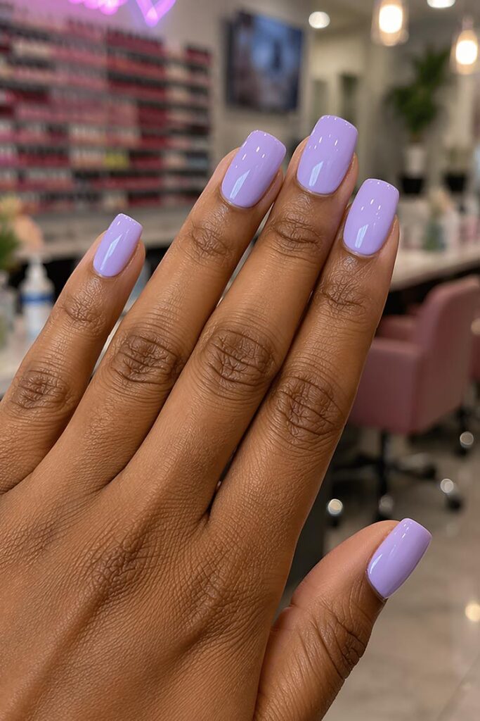 Short square nails painted in glossy lavender polish