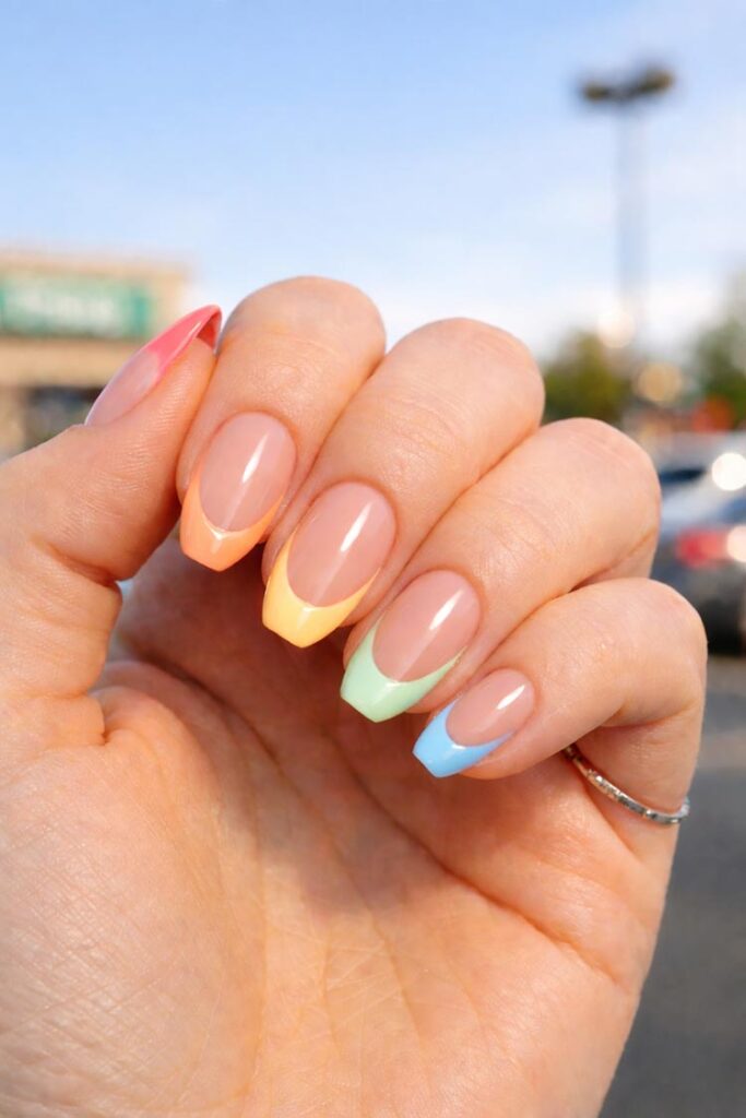 French tip nails with pastel rainbow tips on nude base