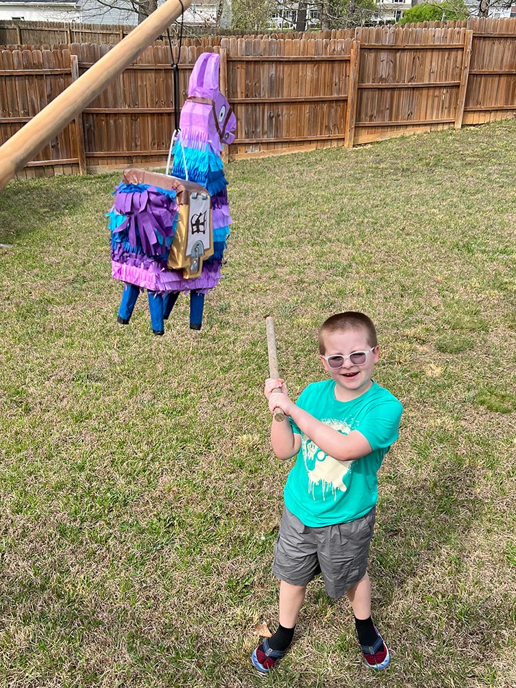Child holding stick ready to hit Fortnite Loot Llama pi&ntilde;ata