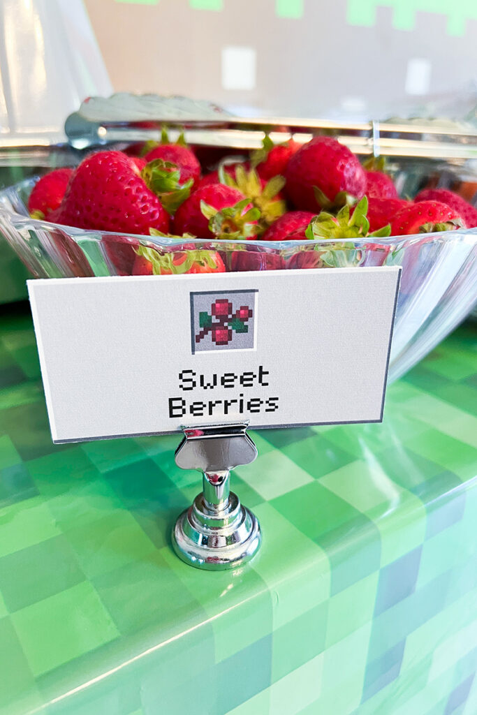 Bowl of strawberries labeled “Sweet Berries” with a Minecraft-style food card on a green pixel tablecloth.