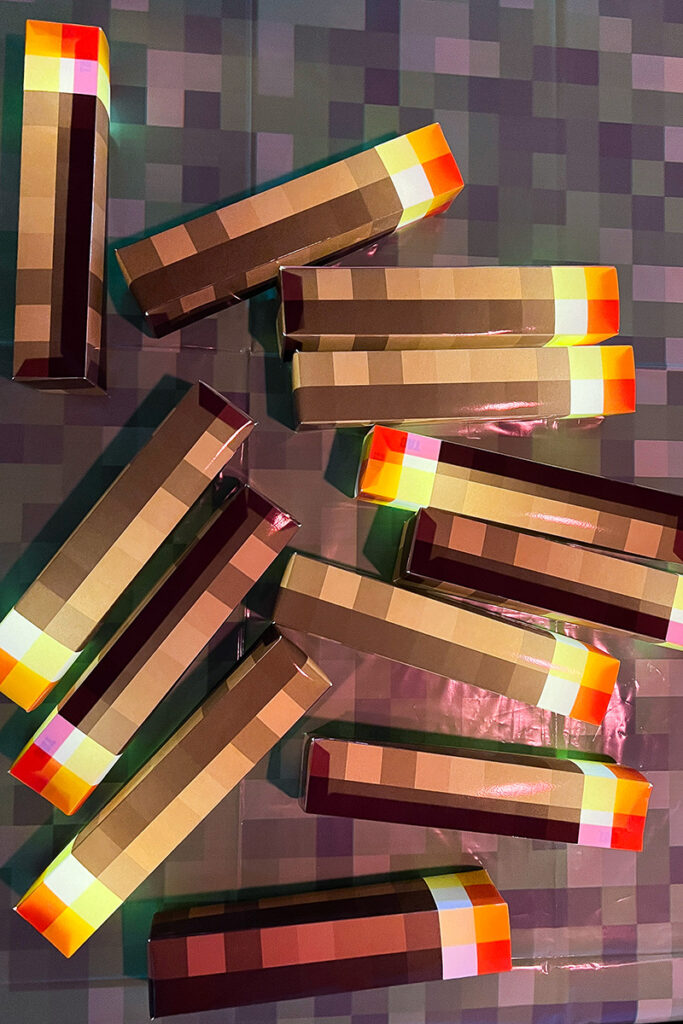 Several handmade Minecraft torch decorations with brown pixel handles and bright orange and yellow flame tips.