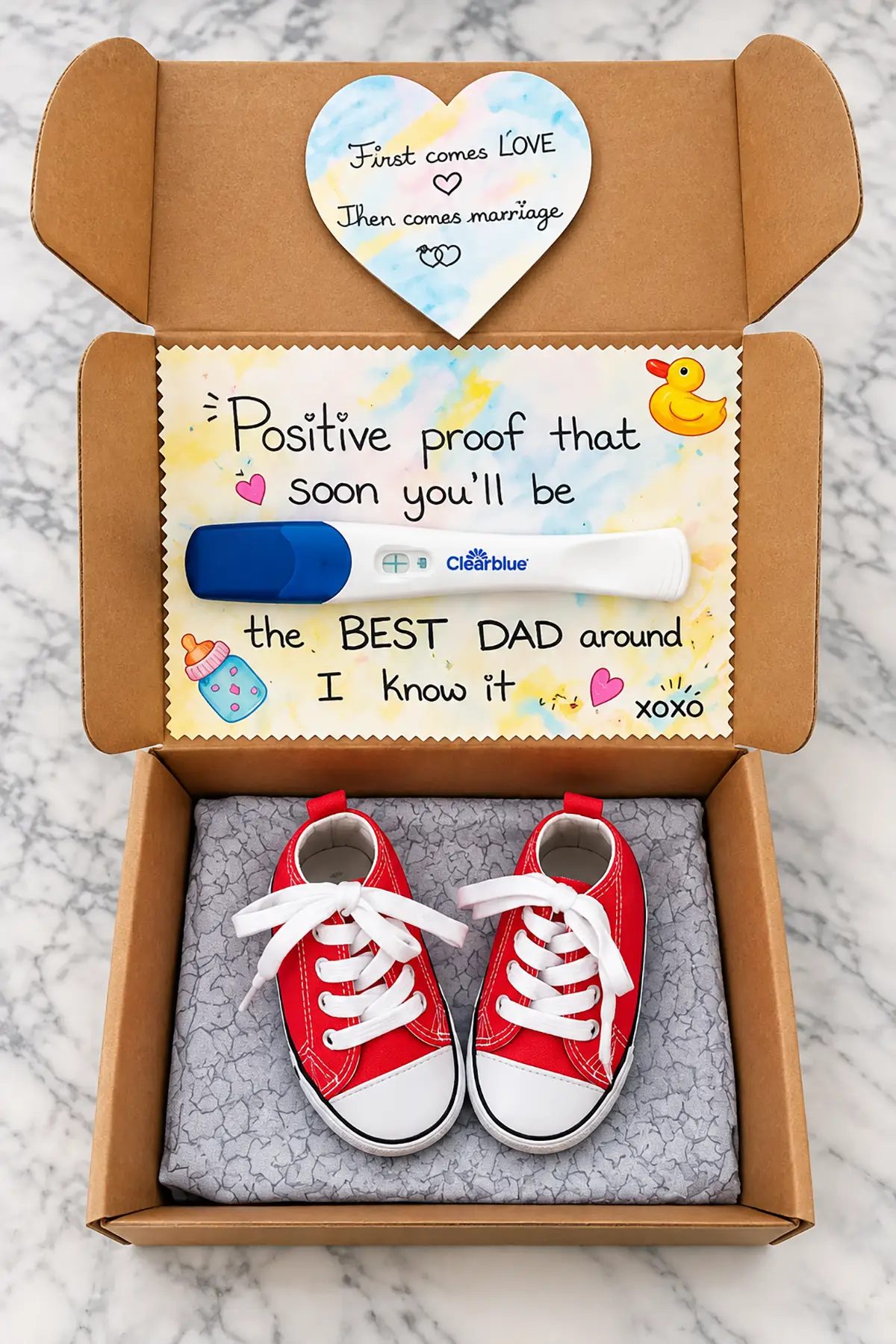 Pregnancy announcement gift box with a positive test, red baby sneakers, and a handmade note telling husband he'll be a dad.